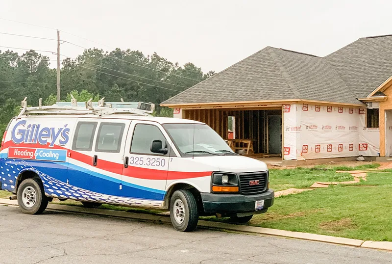 A Gilley's van parked in front of a new house under construction